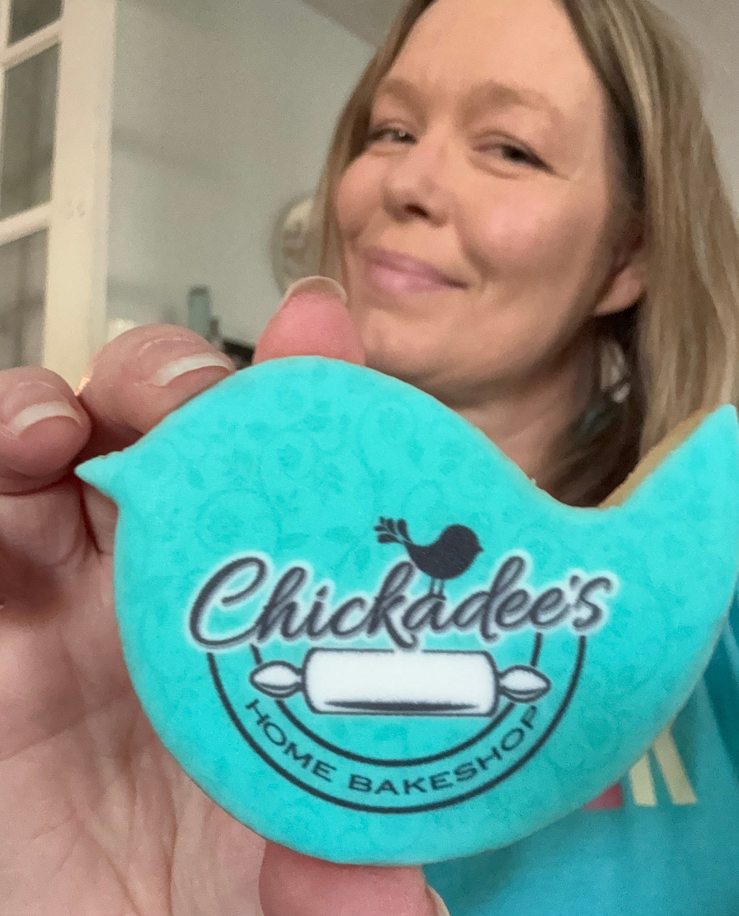 Person holding a teal product with 'Chicladdee's Home Bakeshop' logo.